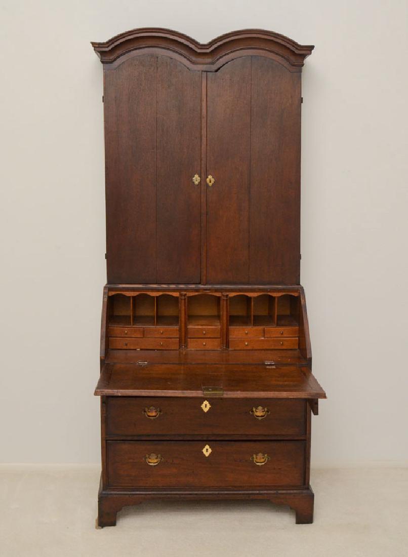 GEORGIAN DOUBLE DOMED BUREAU CABINET: GEORGIAN DOUBLE DOMED BUREAU CABINET: Most likely a marriage, 18th century top with double domed cornice over 2 blind doors with interior wood shelves. Secretary base with slant front opening to fitte