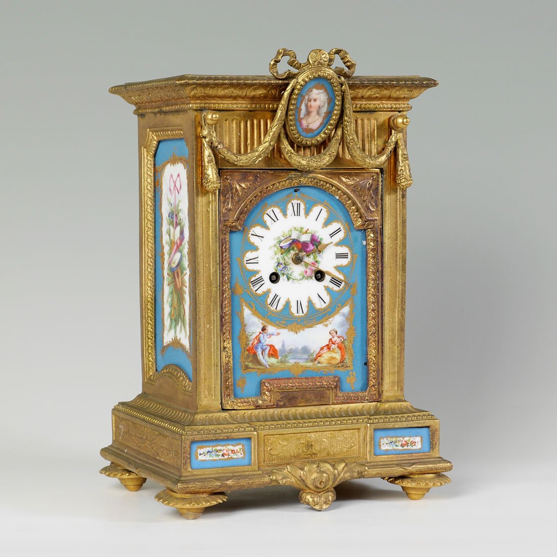 JOHN BENNETT BRONZE DORE & PORCELAIN TILE MANTLE CLOCK: JOHN BENNETT BRONZE DORE & PORCELAIN TILE MANTLE CLOCK: Heavy cast bronze dore case with hand painted tile insert dial, side panels, lower panels. Top applied swag with center porcelain bust of a woma