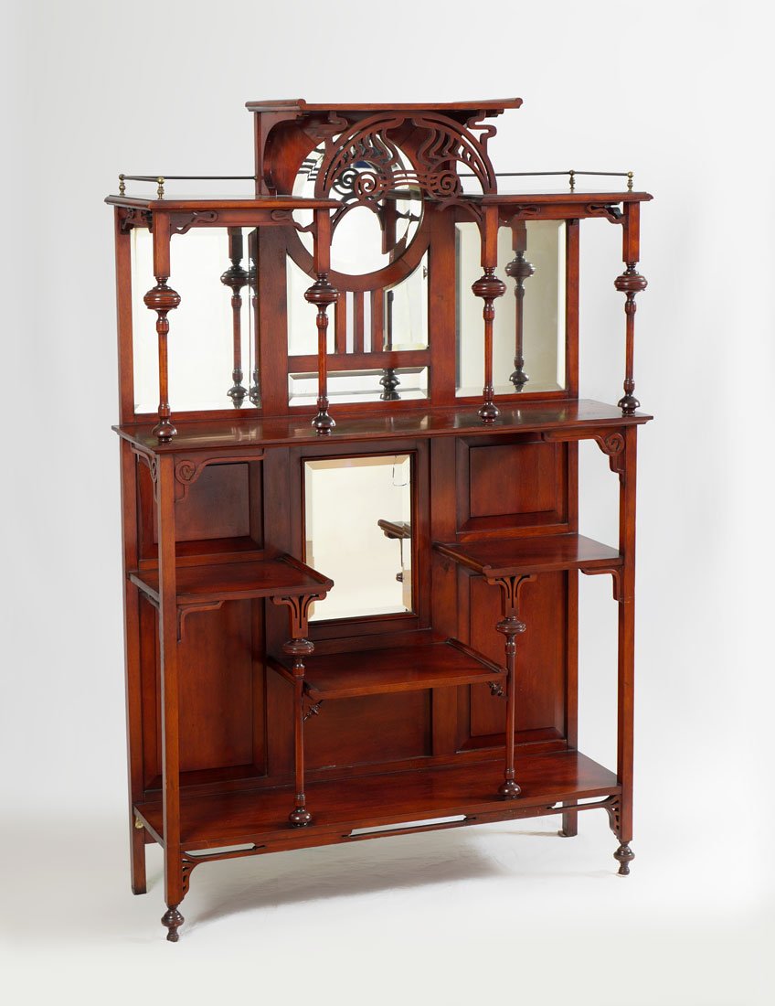 MAHOGANY CARVED EDWARDIAN ETAGERE: MAHOGANY CARVED EDWARDIAN ETAGERE: Raided center top over pierced openwork arch, several levels of open shelves, turned supports, several beveled glass mirror panels, overall 63 1/2'' h. x 42'' x 12 1