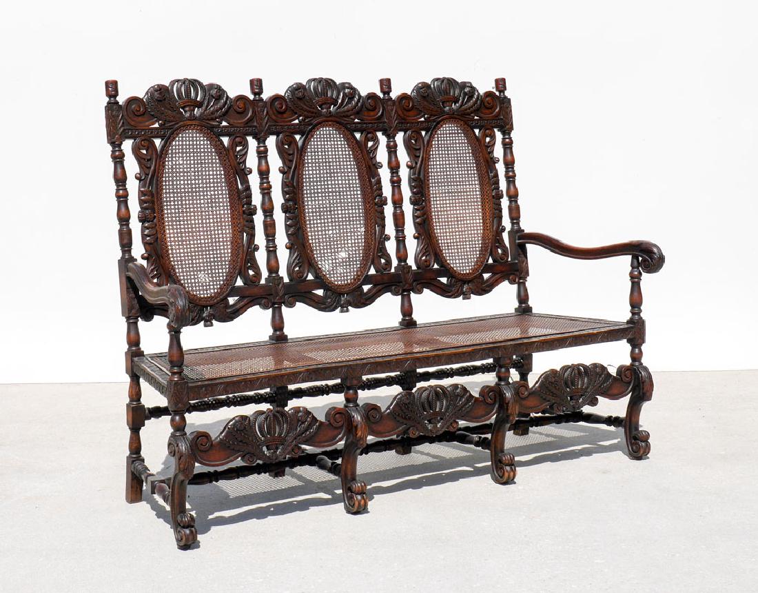 19TH CENTURY SCOTTISH CARVED THISTLE DESIGN BENCH: 19TH CENTURY SCOTTISH CARVED THISTLE DESIGN BENCH: Caned triple medallion back, crest with repeating crown and thistle design, finials with carved faces, shaped arms with acanthus leaf hand holds. Can
