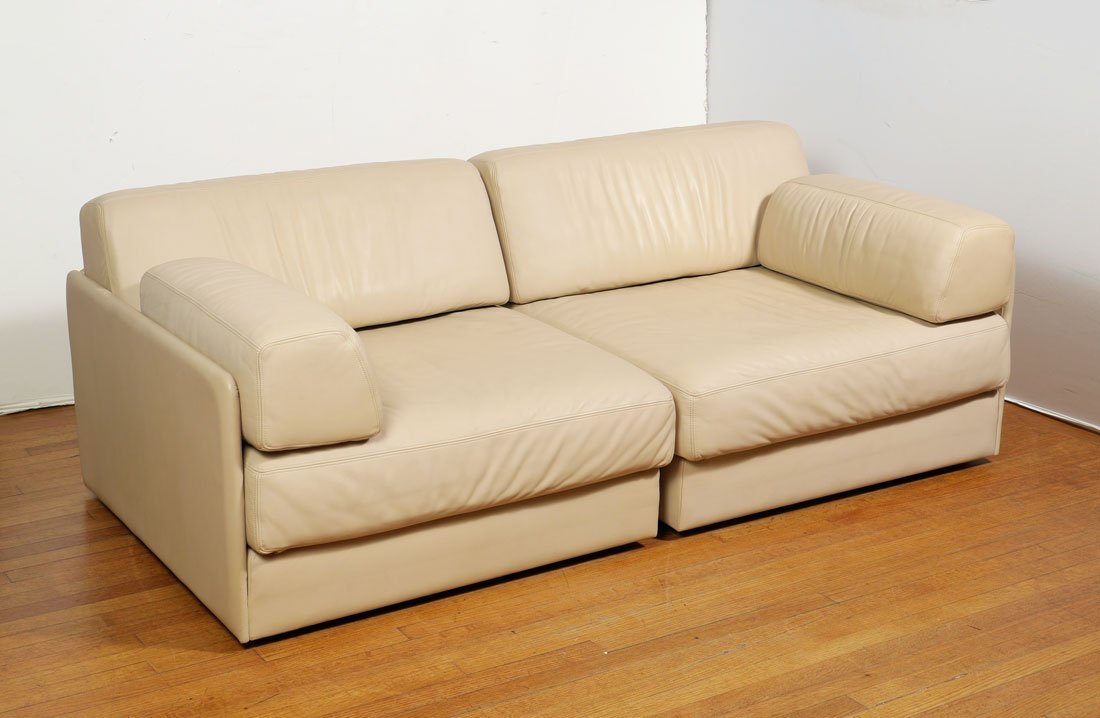 DE SEDE 2 PIECE CONVERTIBLE SECTIONAL LOVESEAT: DE SEDE 2 PIECE CONVERTIBLE SECTIONAL LOVESEAT: Cream leather upholstered sectional loveseat in 2 parts, each section unfolds and convert to bed. Embossed marking on sides. Each module measures 28" h.