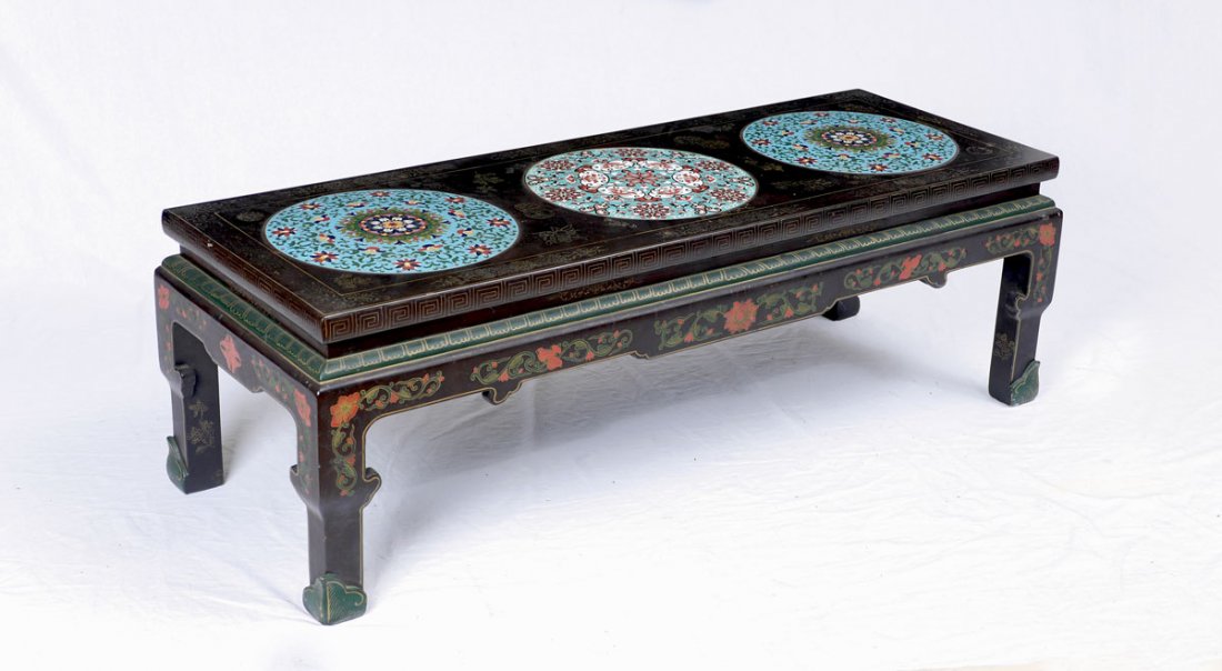 CHINESE COFFEE TABLE WITH 3 CLOISONNE INSERTS: CHINESE COFFEE TABLE WITH 3 CLOISONNE INSERTS: Low black lacquer coffee table with 3 cloisonne medallions inserted into chinoiserie decorated top, shaped skirt with floral motifs, shaped legs, measure