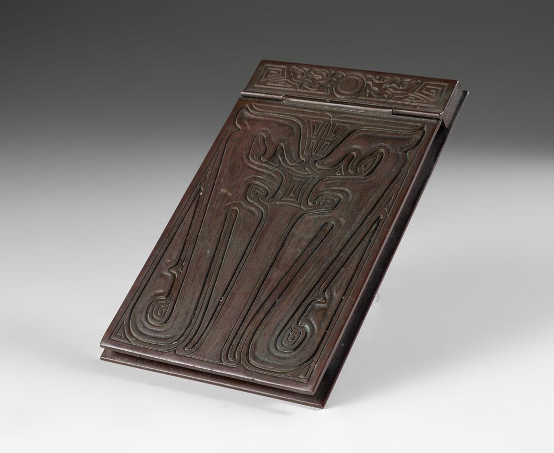 TIFFANY STUDIOS CHINESE PATTERN BRONZE NOTEPAD: TIFFANY STUDIOS CHINESE PATTERN BRONZE NOTEPAD: Bronze notepad in the ''Chinese'' pattern, well marked ''Tiffany Studios, New York, 1758''. Hinged lid, 7 1/2'' x 4 3/4''
