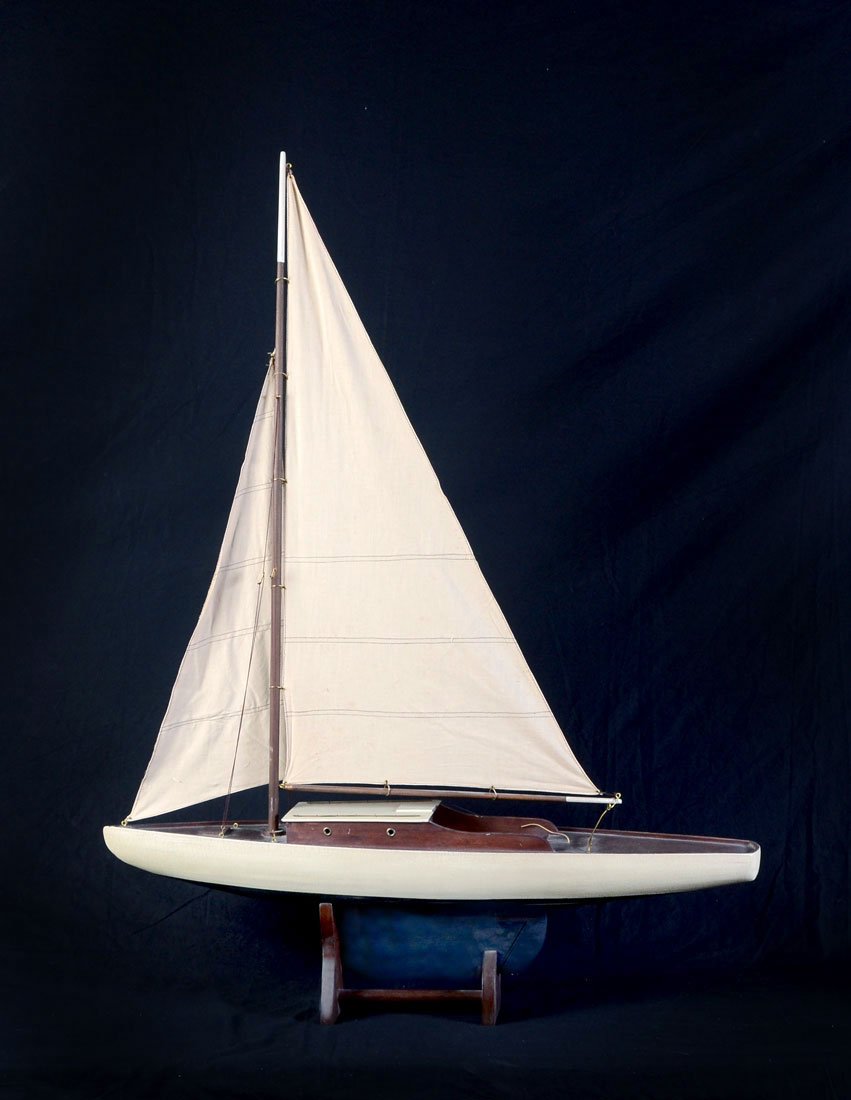 PAINTED WOOD MODEL SAIL POND BOAT: PAINTED WOOD MODEL SAIL POND BOAT: 20th century, antiqued white and blue painted hull, single mast, 2 sails. Measures approx. 45" h. x 36" x 7 1/2". Sold with a 6 1/2" tall stand.