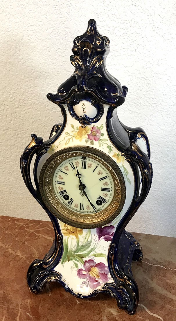 ANSONIA ROYAL BONN PORCELAIN MANTEL CLOCK: ANSONIA ROYAL BONN PORCELAIN MANTEL CLOCK: Cobalt case with openwork handles and floral decor. Works marked Ansonia. Cased marked Royal Bonn. 16" h. x 7 1/4" x 5 1/4".