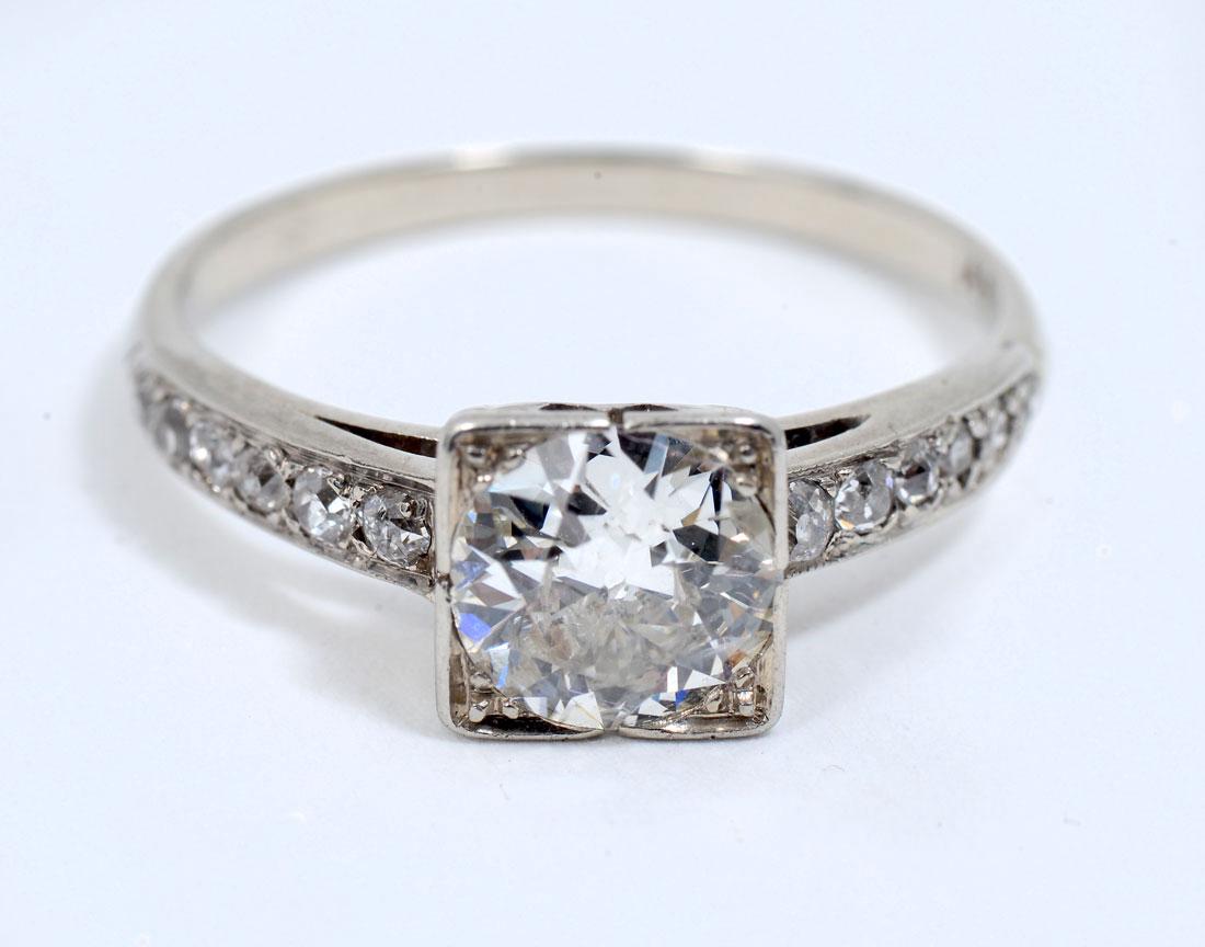 14K ARTDECO 1.0CT DIAMOND RING: 14K ARTDECO 1.0CT DIAMOND RING: 1.00CT circular brilliant cut diamond is featured in this beautiful art deco ring in white gold. 12 round full cut, single cut and Swiss cut diamonds drape down the sho