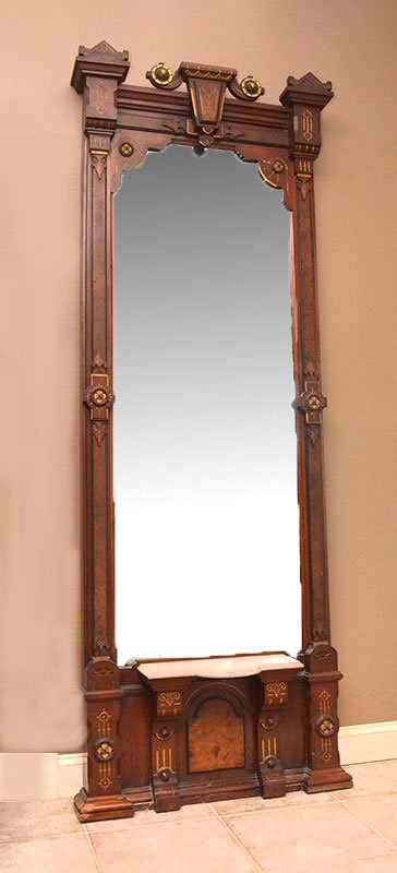 HIGH VICTORIAN WALNUT PIER MIRROR: HIGH VICTORIAN WALNUT PIER MIRROR: Center crest with carved gilt accents, frame with applied carved and burl veneer decoration, lower shaped marble shelf. 98'' h. x 35 1/2'' x 10 1/2''.