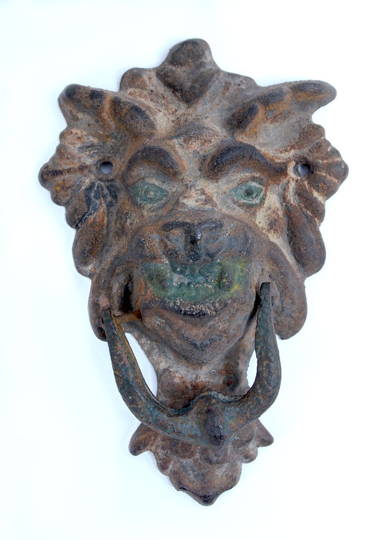 CAST IRON GARGOYLE DOOR KNOCKER: CAST IRON GARGOYLE DOOR KNOCKER: Gargoyle masqueron form with traces of paint remaining, 11 1/2" h. x 7" x 3 1/4".