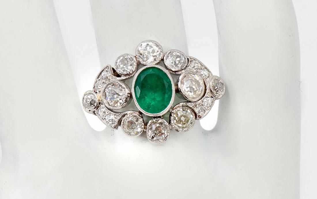 PLATINUM EDWARDIAN EMERALD & DIAMOND RING: PLATINUM EDWARDIAN EMERALD & DIAMOND RING: 1.16CT oval mixed cut emerald is bezel set amid 18 sparkling old European round cut diamonds. Diamond weight 2.50CTW rated SI in clarity and H-I-J in color. 