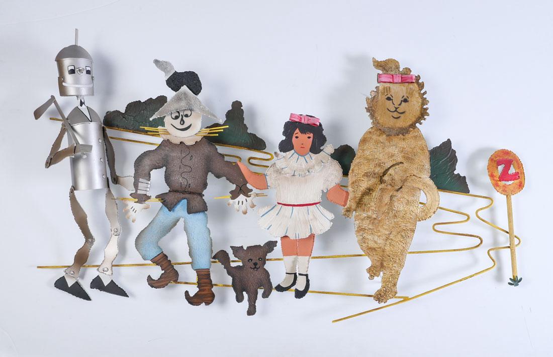 CURTIS JERE WIZARD OF OZ WALL SCULPTURE: CURTIS JERE WIZARD OF OZ WALL SCULPTURE: Depicts the full cast of characters: Tinman, Scarecrow, Dorothy, Toto and The Cowardly Lion, Painted Metal, signed and dated 1995, approximately 25" x 45.50".