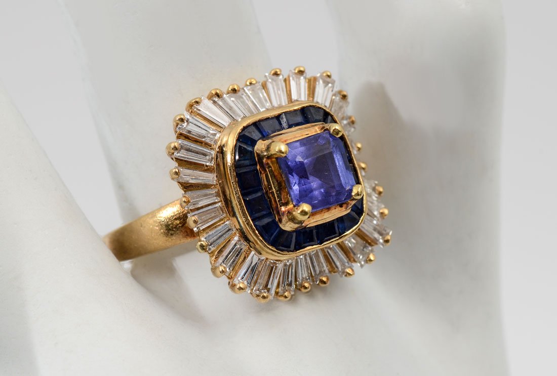 BOLD 18K TANZANITE, SAPPHIRE & DIAMOND RING: BOLD 18K TANZANITE, SAPPHIRE & DIAMOND RING: 18K yellow gold ring contains one square step cut tanzanite. WEIGHT: 1.07 Ct. Approx. VS in clarity (Type I), P in Hue, 5 in Tone and 3 in Saturation. 16 s