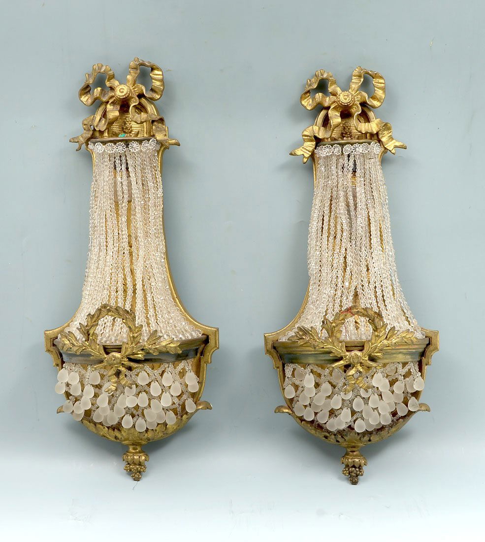EARLY 20TH CENTURY GILT BRONZE FRENCH SCONCES: EARLY 20TH CENTURY GILT BRONZE FRENCH SCONCES: An elegant pair of Gilt Bronze French wall Scones decorated with stringed crystal beads and satin crystal drops. Wired for electric. Approx. 19'' h x 8''