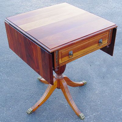 CHERRY DROP LEAF SIDE TABLE: CHERRY DROP LEAF SIDE TABLE: Duncan Phyfe style pedestal base, 4 legs ending in brass paw feet. Single drawer with lion head pulls. 30 1/2" high X 24" wide X 23 3/4" deep. 45" wide with leaves extende
