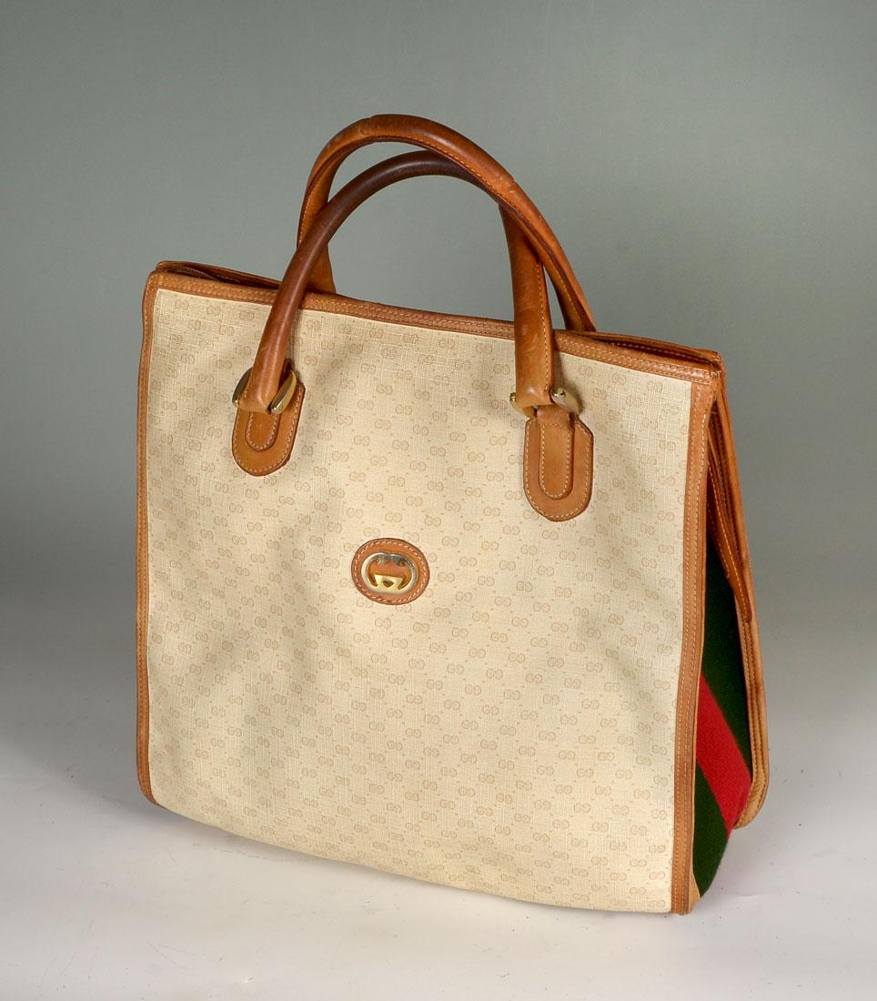 VINTAGE MONOGRAMMED GUCCI TOTE WITH BROWN LEATHER TRIM: VINTAGE MONOGRAMMED GUCCI TOTE WITH BROWN LEATHER TRIM: Vintage GG logo on beige canvas with brown leather trim. Classic Gucci red and green stripes on each side with gold hardware. One internal zippe
