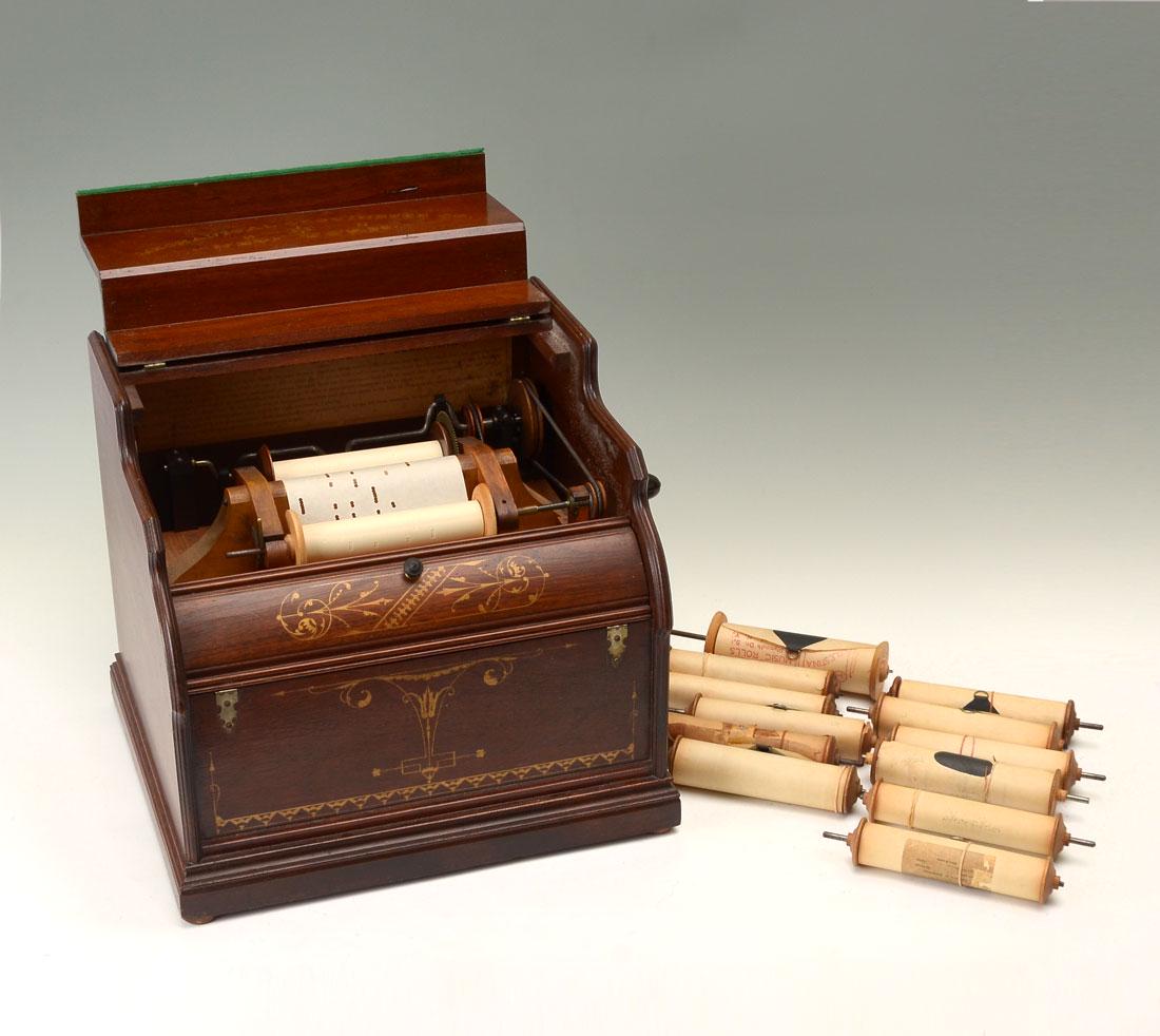 MECHANICAL CELESTINA ORGUINETTE WITH 12 ROLLS: MECHANICAL CELESTINA ORGUINETTE WITH 12 ROLLS: Sometimes known as Barrel Organs or Celestinas, this example with walnut, gilt decorated hinged lid which opens to reveal maker's name Mechanical Orguine