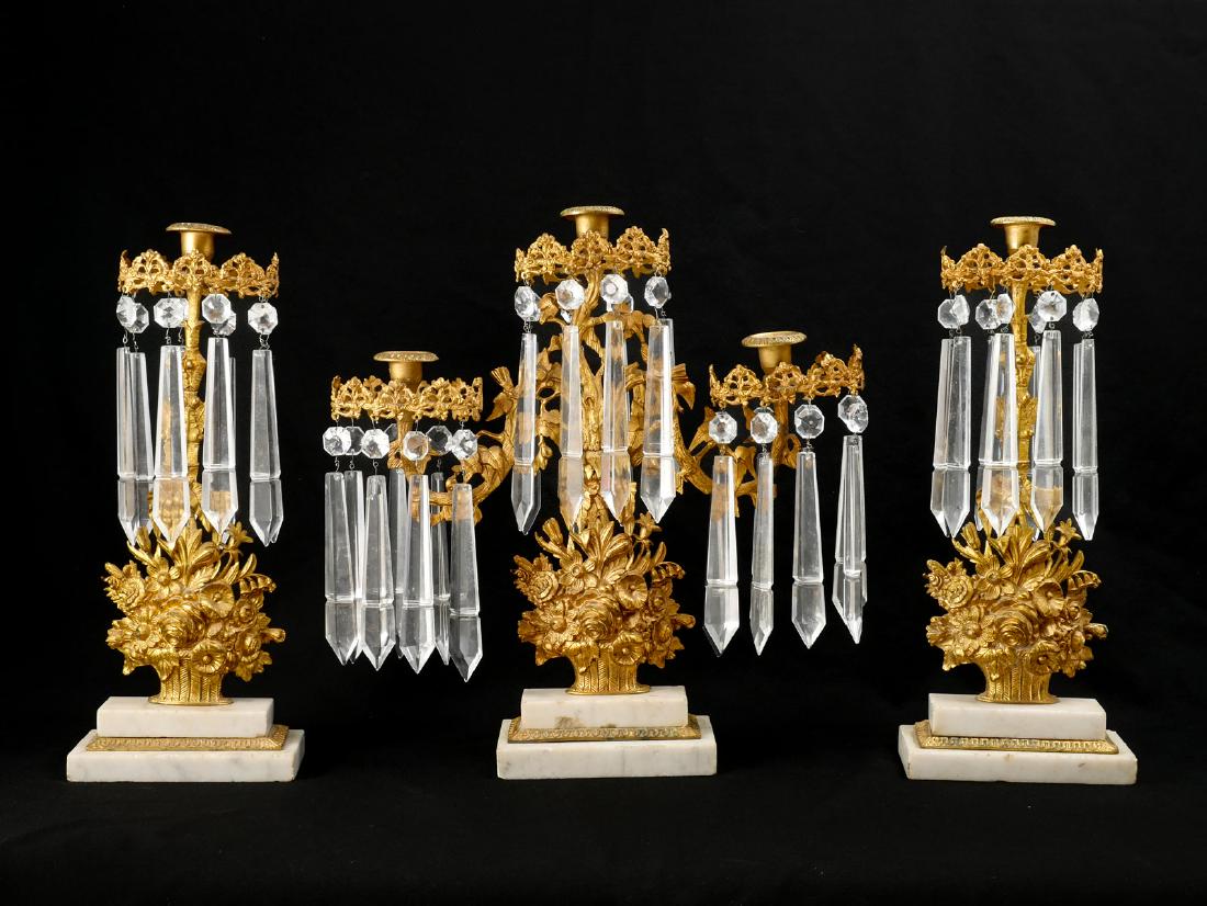 3 PIECE GILT CANDELABRA SET ON MARBLE: 3 PIECE GILT CANDELABRA SET ON MARBLE: Included are 2 single Gilt brass candle holders in the form of a bountiful flower basket with a foliate collar adorned by multi-faceted and spear shaped prisms. 