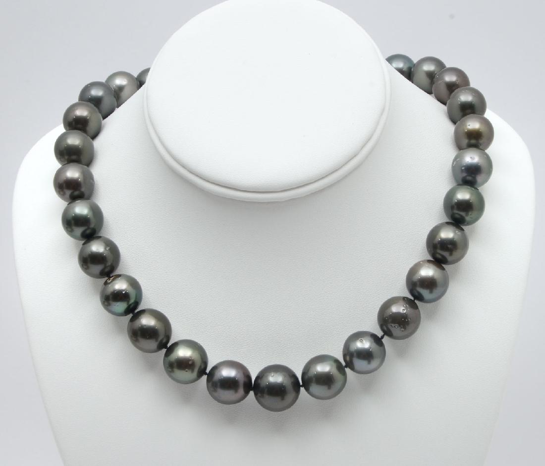 GRADUATED STRAND OF TAHITIAN ''BLACK'' PEARLS: GRADUATED STRAND OF TAHITIAN ''BLACK'' PEARLS: Grey-black pearls range from 14.00MM TO 16.00MM, are lightly blemished and have very good luster. 18.25'' Princess length, knotted with a 14k white gold 