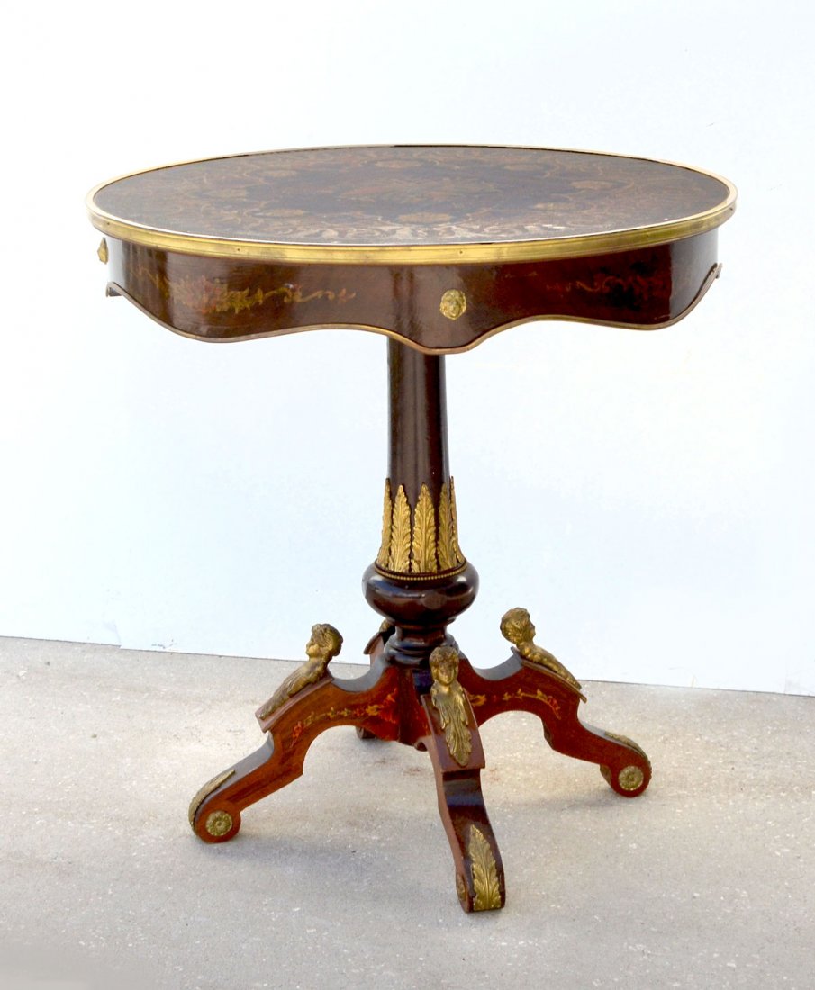 ORMOLU MOUNTED ROUND LAMP TABLE: ORMOLU MOUNTED ROUND LAMP TABLE: Table has a center medallion inlaid with a musical motif with a floral & scrolling foliate design encompassing. Lion head ormolu mounts and foliate inlaid serpentine s