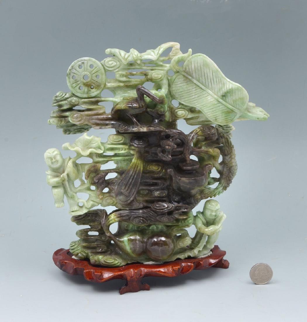 VARIEGATED GREEN JADE BUDDHIST CARVING: VARIEGATED GREEN JADE BUDDHIST CARVING: Carved & pierced variegated green jade with 2 boys carrying a leaf, a double gourd with the Water of Life flowing from it, 4 bats, 2 cranes, and a Taoist fan. A