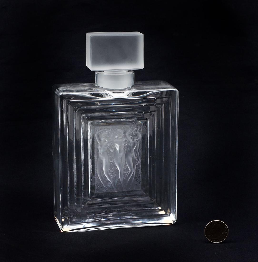 LALIQUE DUNCAN PERFUME BOTTLE: LALIQUE DUNCAN PERFUME BOTTLE: Art deco nude Lalique Duncan perfume bottle with 3 frosted nude dancers in center surrounded by graduated rectangles and topped with a frosted stopper. Designed by Rene 