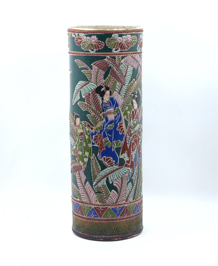 JAPANESE MORIAGE UMBRELLA STAND: JAPANESE MORIAGE UMBRELLA STAND: Japanese umbrella stand having a dark green ground with 3 geisha girls amongst palm leaves. Floral border at top and a spiral border at bottom. No makers mark. Approx.