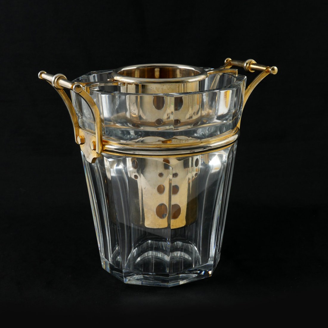 BACCARAT CRYSTAL ICE BUCKET: BACCARAT CRYSTAL ICE BUCKET: Optic paneled Baccarat crystal ice bucket with an encompassing plated brass ring having attached handles. Plated wine bottle holder rests in center on a supported collar t