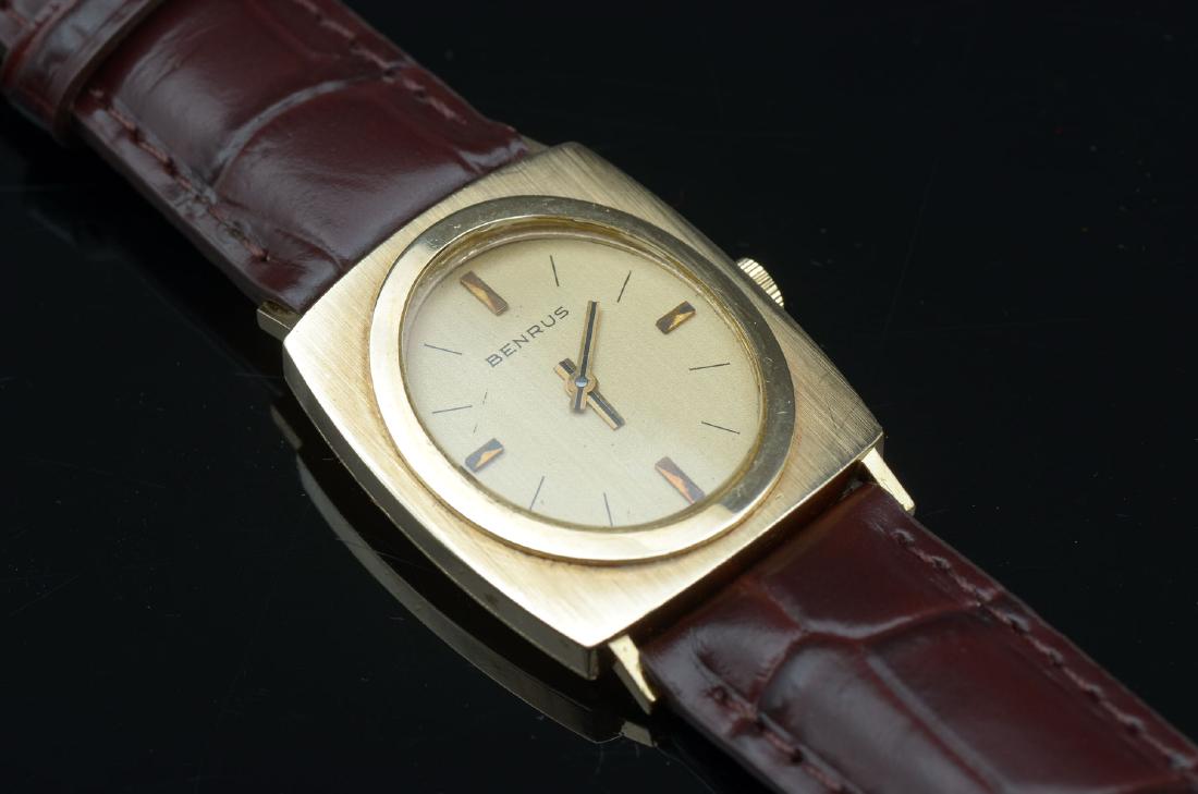 VINTAGE BENRUS 14K WRIST WATCH: VINTAGE BENRUS 14K WRIST WATCH: Handsome yellow gold rectangular case with oval face. Champagne dial has gold color hour markers and hands. Handsome new brown leather band can be adjusted from 6'' to 