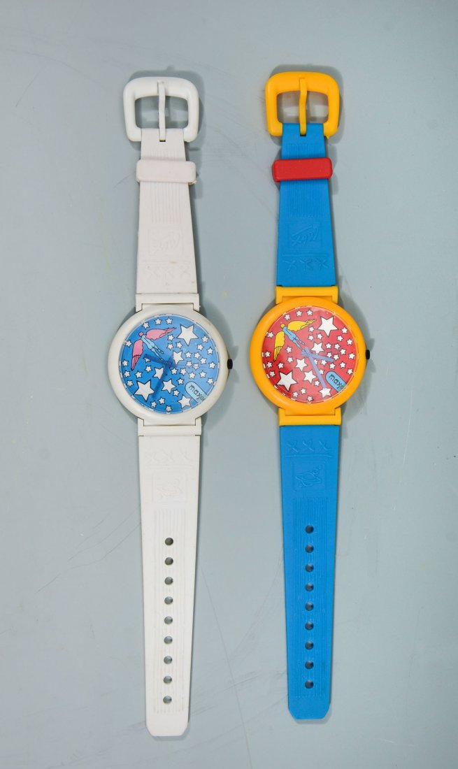 2 PETER MAX "ANGEL" WATCHES: 2 PETER MAX "ANGEL" WATCHES: 2 watches, both in original boxes. 1) Blue angel with pink wings and white stars on blue background in white case with white buckle. White strap can be adjusted to 5.5"" t