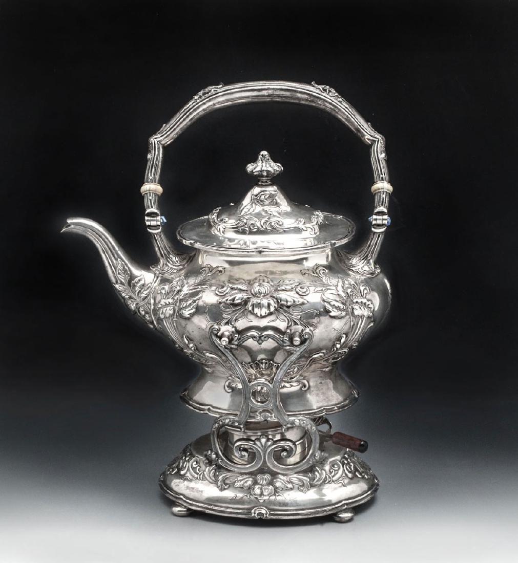 GORHAM STERLING SILVER TEA KETTLE ON STAND: GORHAM STERLING SILVER TEA KETTLE ON STAND: Having an overall floral & scrolling foliate design to kettle and stand with an adjustable burner with wood handle in center. Impressed Gorham compass mark 