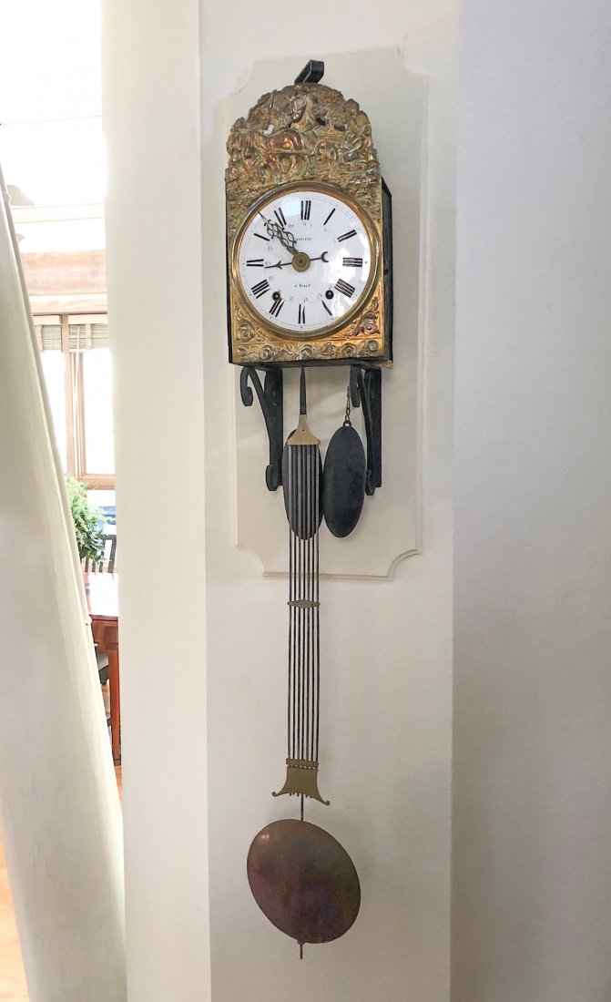 WAG ON THE WALL CLOCK: WAG ON THE WALL CLOCK: Surmounted by a large brass bell chime and an embossed copper farming scene with lower rose & scrolling design. White enameled face having black roman numerals. Approx. 55.5" h