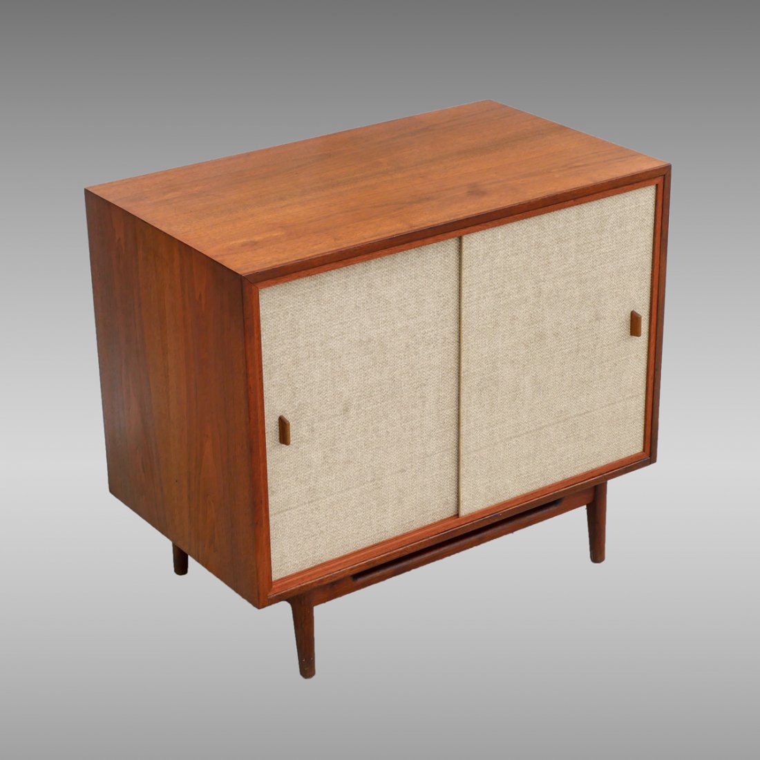 JENS RISOM MID-CENTURY CABINET: JENS RISOM MID-CENTURY CABINET: Mid-century 2-door cabinet having a single shelf interior, raised on tapered legs. Original Jens Risom Design Inc. sticker resides on verso. Approx. 31.75" h x 36" l x