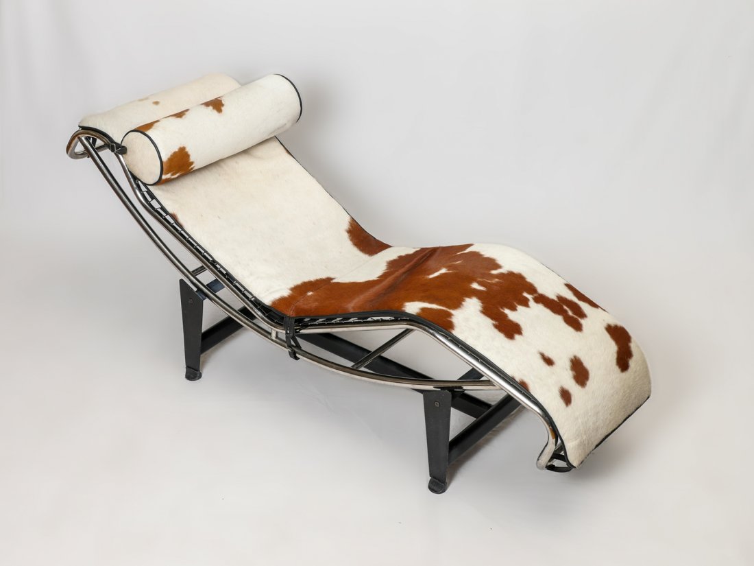 LE CORBUSIER MODERN CHAISE LOUNGE: LE CORBUSIER MODERN CHAISE LOUNGE: Moderne cow hyde chaise lounge having black metal frame with rubber wrapped top rails for adjusting position of chaise lounge. Approx. 25" h x 66" l x 22.5" w.