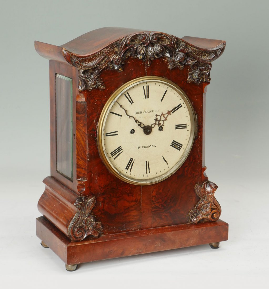 JOHN COCKBURN RICHMOND MANTLE CLOCK: JOHN COCKBURN RICHMOND MANTLE CLOCK: Case with beveled glass sides, carved floral drapery, burl veneer, white enameled face. Approx. 17.75" h x 13.75" l x 7.25" w.