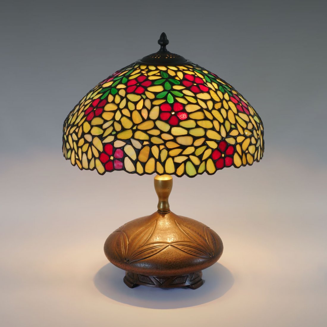 COPPER CLAD TIFFANY STYLE LAMP: COPPER CLAD TIFFANY STYLE LAMP: Tiffany style copper clad lamp having a triple leaf design encompassing, Red flower & green foliate slag glass shade. Underside bares an impressed Tiffany Studios New Y