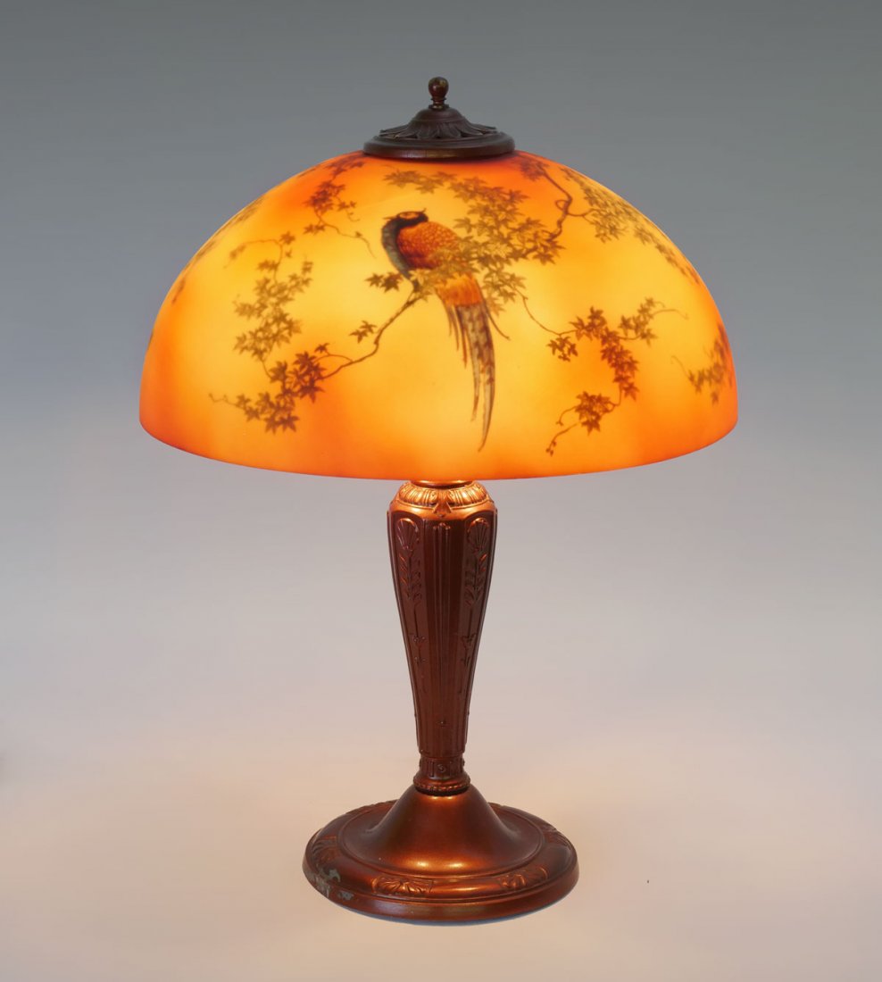 REVERSE PAINTED LAMP WITH BIRD MOTIF: REVERSE PAINTED LAMP WITH BIRD MOTIF: Reverse painted lamp shade having 2 birds resting in tree foliate, resting on a painted art deco base with floral panels. Approx. 20" h x 16" w.