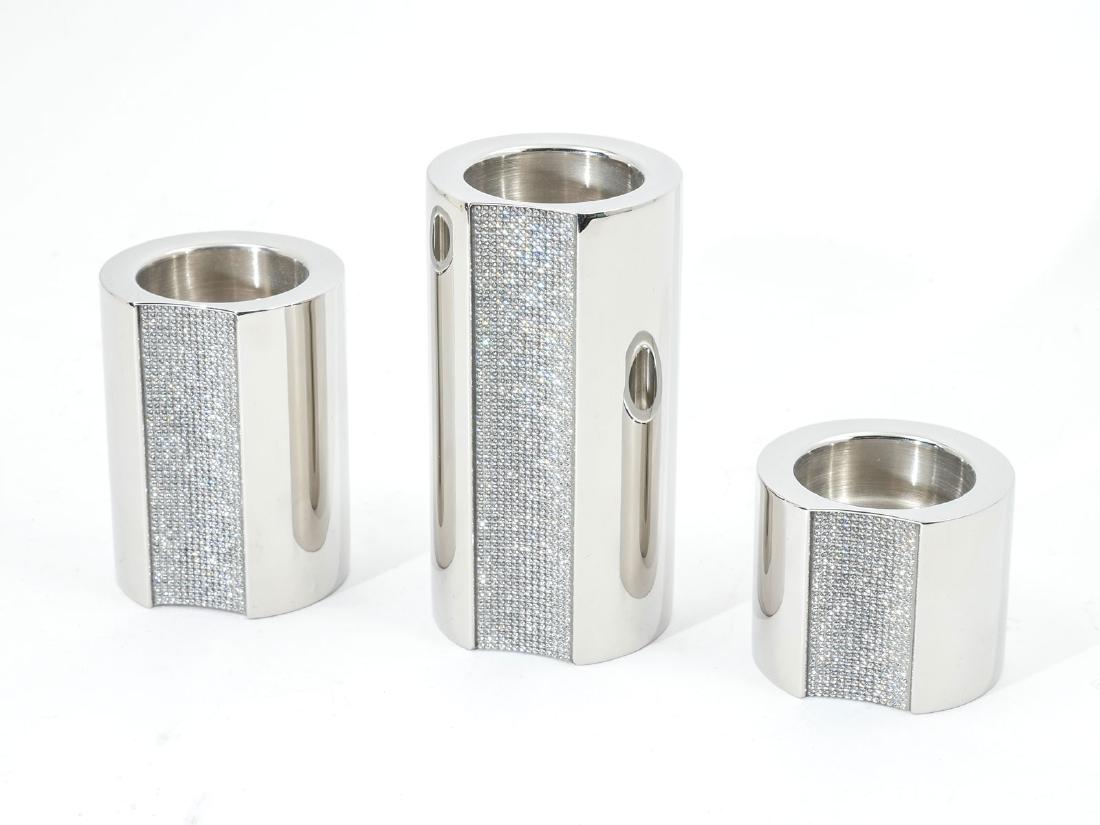 SWAROVSKI "AMBIRAY" SS & CRYSTAL VOTIVE CANDLE-HOLDERS: SWAROVSKI "AMBIRAY" SS & CRYSTAL VOTIVE CANDLE-HOLDERS: A votive candleholder set in the Ambiray pattern by Swarovski. These three pieces graduated sizes - 2", 3" and 4.5" in cylindrical stainless-ste