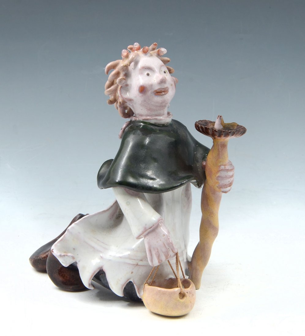WIENER WERKSTATTE CHOIR BOY WITH CANDLE: SINGER FOR WIENER WERKSTATTE CHOIR BOY WITH CANDLE: Kneeling choir boy is holding a candle and carrying a basket with black cape and white robe. 5" h x 4.5" deep. Glazed ceramic figure is marked WW an