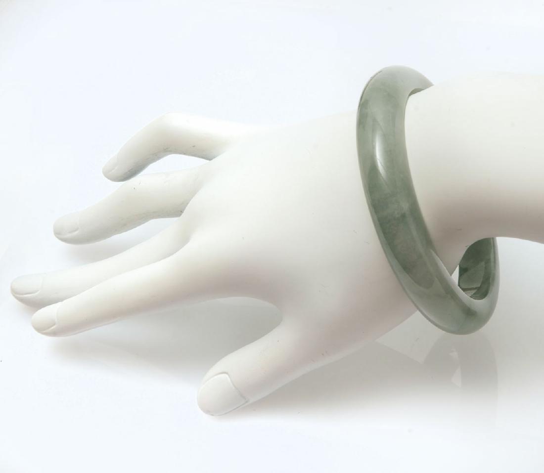 JADE BANGLE BRACELET: JADE BANGLE BRACELET: Really lovely soft green tones. Measures inside 7.25''. Natural Fei Cui - type A. Sold with appraisal from Hong Kong Jade & Stone Laboratory Limited for $2180.