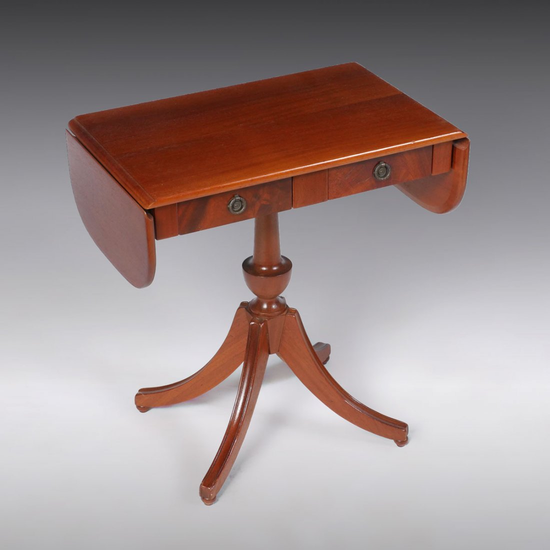 2 DRAWER DUNCAN PHYFE DROP LEAF TABLE: 2 DRAWER DUNCAN PHYFE DROP LEAF TABLE: Duncan Phyfe drop leaf table having 2 drawers raised on a central turned support with 4 incised sprawling legs and ball feet. Approx. 25" h x 36" l (open), 23.25