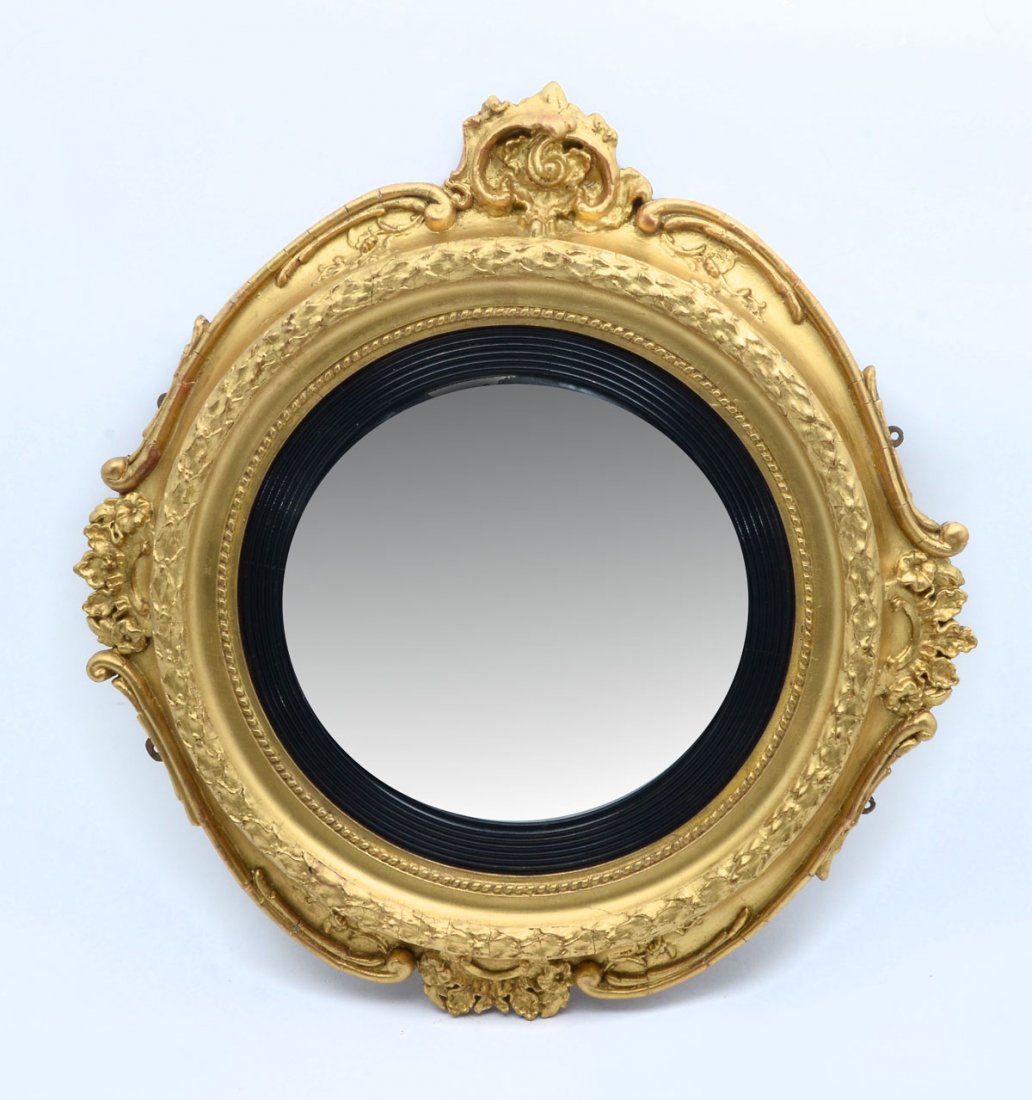 GILT & EBONIZED ROCOCCO CONVEX MIRROR: GILT & EBONIZED ROCOCCO CONVEX MIRROR: Convex mirror with an incised ebonized design encompassing with a surrounding Gilt foliate & scrolling border. Approx. 37.25" h x 26.25" l x 2" w.