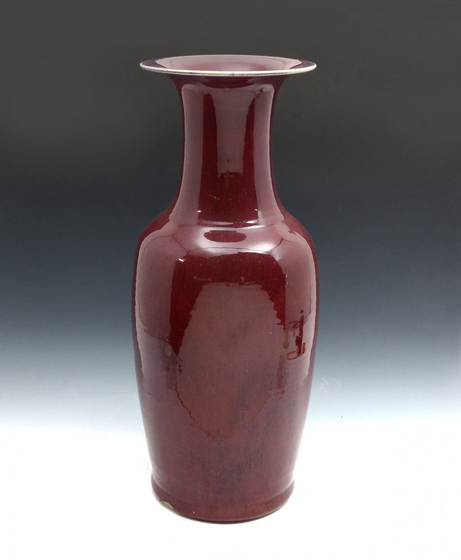 CHINESE OX BLOOD FLOOR VASE: CHINESE OX BLOOD FLOOR VASE: Chinese ox blood drip glazed floor vase in baluster form having a flared rim with white edge. Rough bottom rim. Approx. 22.25" h x 9.5" w.