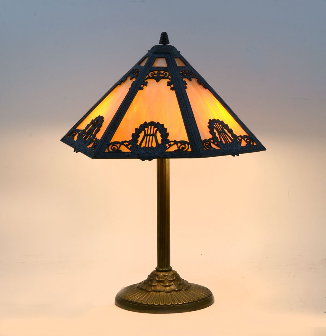 RAINAUD SLAG GLASS LAMP: RAINAUD SLAG GLASS LAMP: Caramel slag glass lamp having 2 lights, 6 panels with harp & wreath medallions and scrolling foliate design. Bee hive finial, foliate base. Underside stamped Rainaud, 1118. A