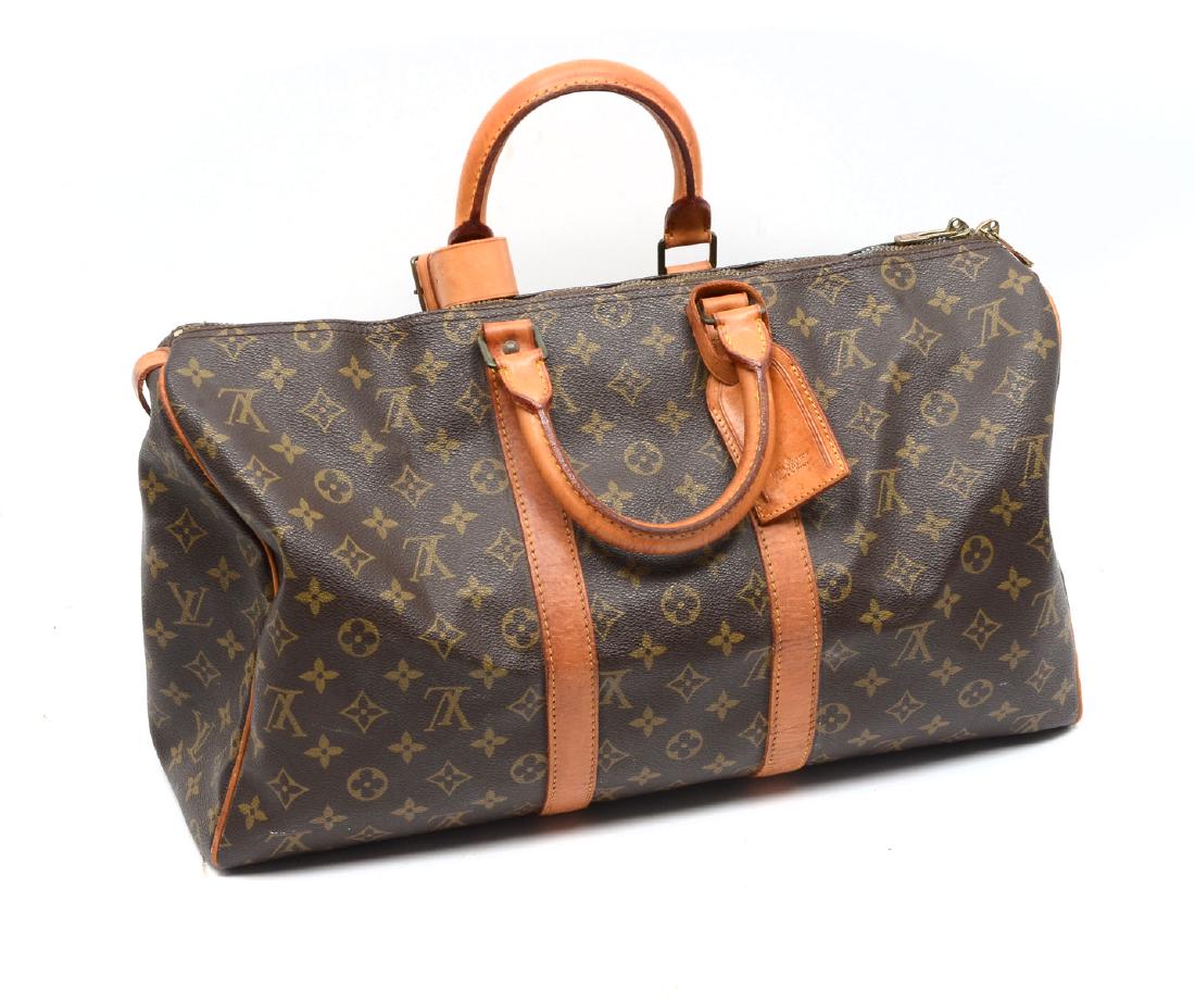 LOUIS VUITTON DUFFLE/KEEPALL MONOGRAM CANVAS BAG: LOUIS VUITTON DUFFLE/KEEPALL MONOGRAM CANVAS BAG: Louis Vuitton Keepall 50 is a classic of the Louis Vuitton travel bag collection. This spacious medium sized version in Monogram canvas and a double b