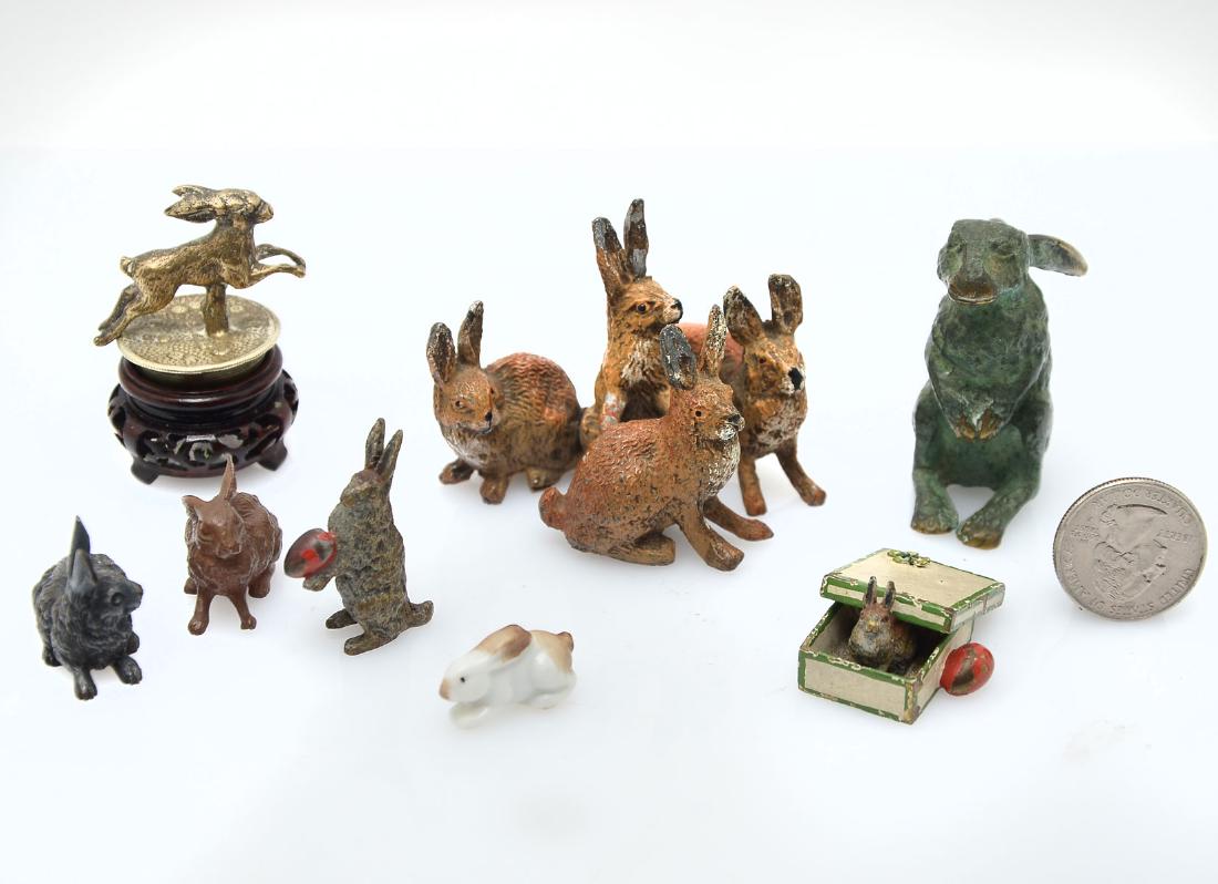 LOT OF MINIATURE RABBITS: LOT OF MINIATURE RABBITS: Comprising 1 silvered copper cork topper, 1 painted brass rabbit in a box with an egg at side, 1- porcelain rabbit, 3- painted copper rabbits, 1- patinated bronze rabbit, & 1
