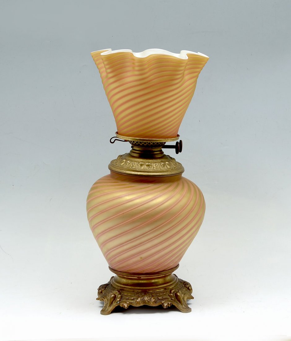 RARE THOMAS WEBB & SONS GLASS OIL LAMP: RARE THOMAS WEBB & SONS GLASS OIL LAMP: Late 19th century double burner oil lamp having an overall spiraling gold & orange glass design to body & shade. Mounted on a scrolling foliate designed base an