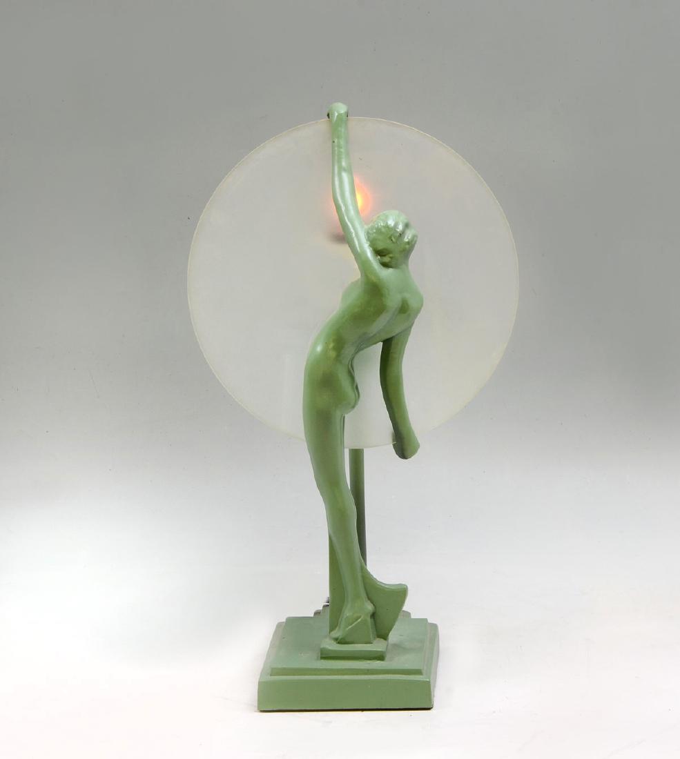 FRANKART NUDE FEMALE LAMP: FRANKART NUDE FEMALE LAMP: Art deco Frankart lamp having a nude woman holding a frosted glass disc shade. Approx. 14.5'' h x 5.5'' l x 4.25'' w.