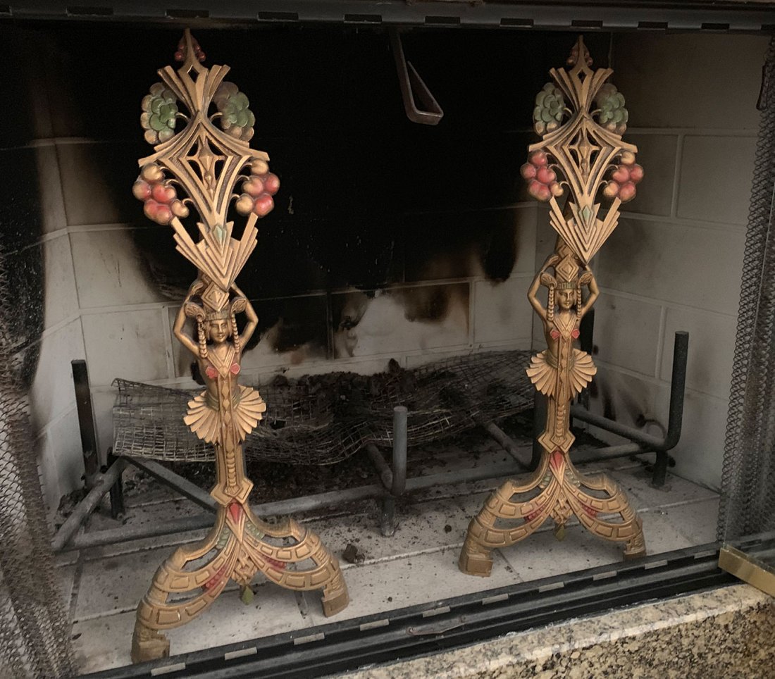 ART DECO FIGURAL ANDIRONS: ART DECO FIGURAL ANDIRONS: Pair of Art Deco Egyptian Revival andirons. Made by the Universal Electric Log Co., Chicago. Approx. 23" h x 13.25" x 9" w.
