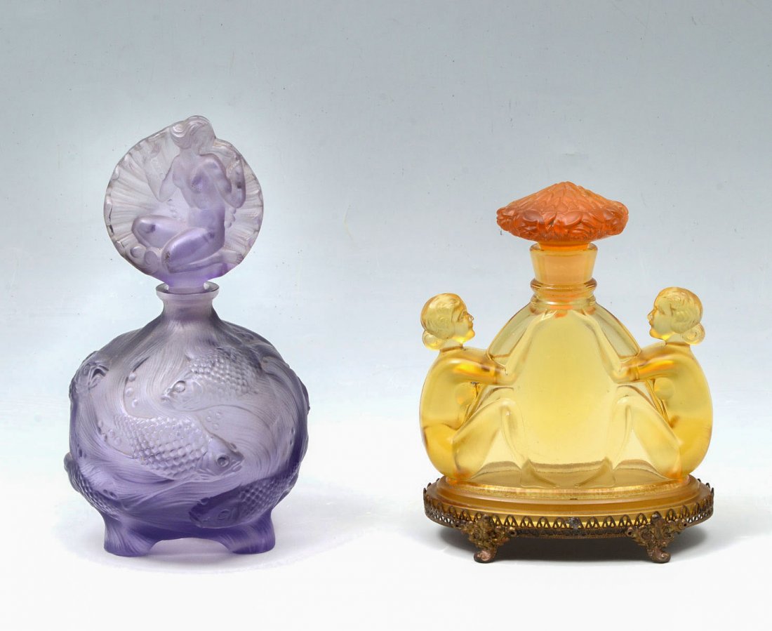 CZECH AMBER NUDE & CURT SCHLEVOGT CO PERFUME BOTTLES: CZECH AMBER NUDE & CURT SCHLEVOGT CO PERFUME BOTTLES: l) 1920s Czech amber glass perfume bottle and stopper flanked by nude women on footed metal base. Measures 5.75" h x 4.5" w; 2) Circa 1920s - 30s,