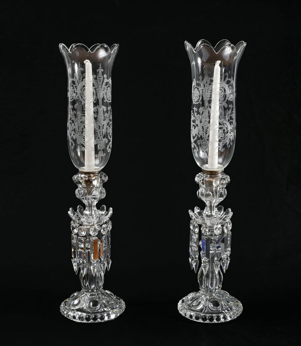 2 BACCARAT MANTLE LUSTERS: 2 BACCARAT MANTLE LUSTERS: 2 Baccarat candlestick mantle lusters having a floriform shade with an etched scrolling foliate design. Adorned by multi-faceted spear shaped crystals. Underside bares the e