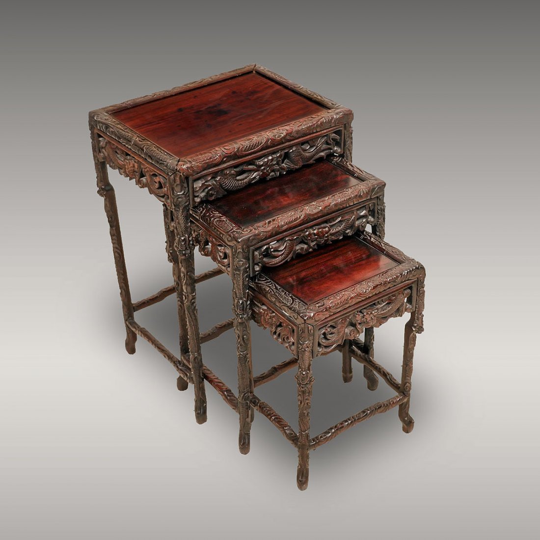 EXQUISITELY CARVED CHINESE NESTING TABLES: EXQUISITELY CARVED CHINESE NESTING TABLES: 3 intricately carved Chinese nesting tables having an overall carved & pierced dragons amongst clouds design. Largest Approx. 24.75" h x 17.25" l x 13" w.